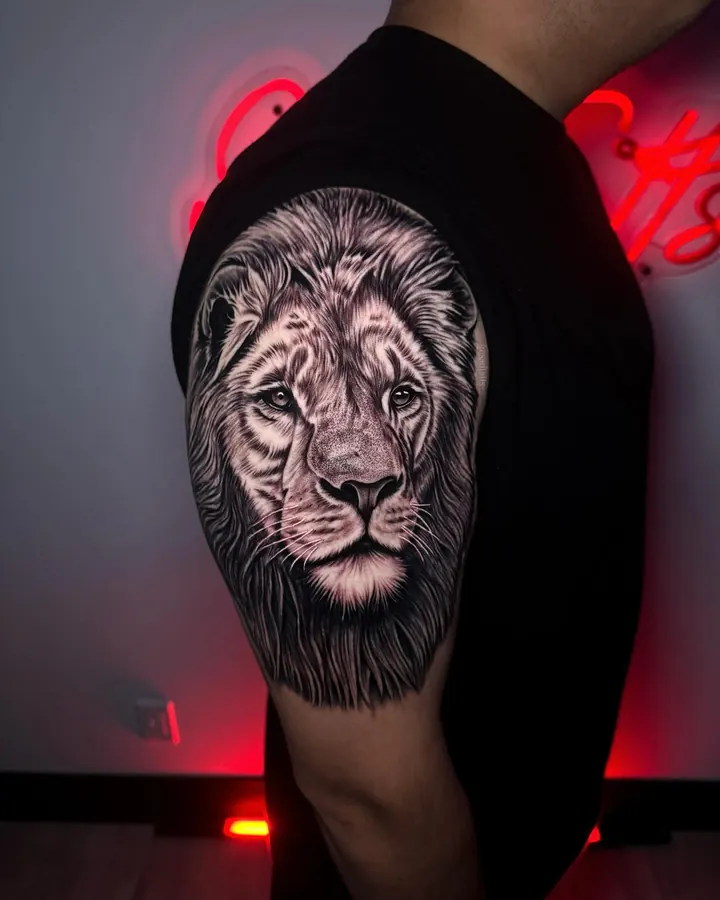 Black and grey tattoo by Dre: lion, shoulder