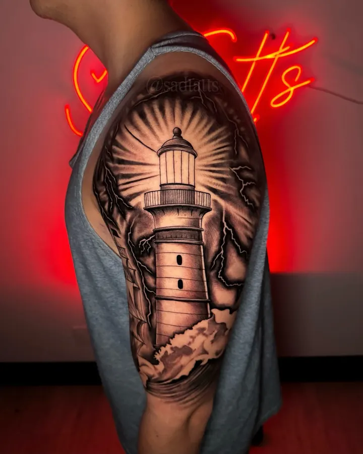 Black and grey tattoo by Dre: lighthouse, shoulder