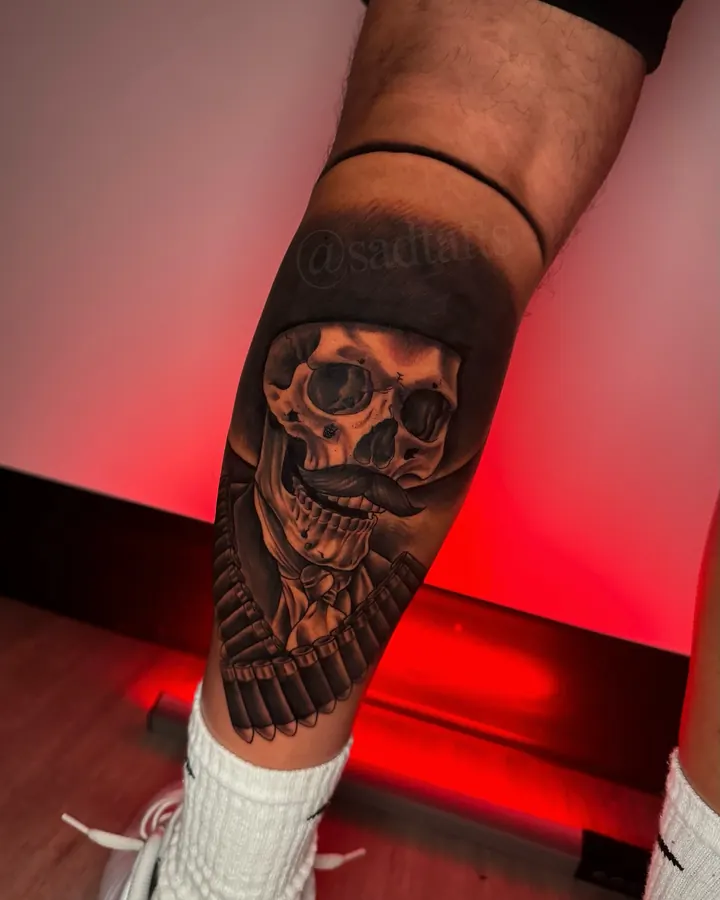 Black and grey tattoo by Dre: skull, forearm