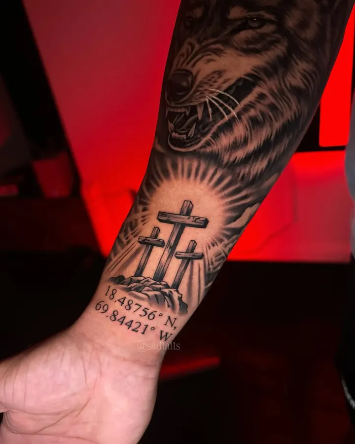 Black and grey tattoo by Dre: wolf and crosses, forearm