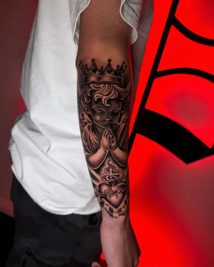 Black and grey tattoo by Dre: crowned figure, forearm