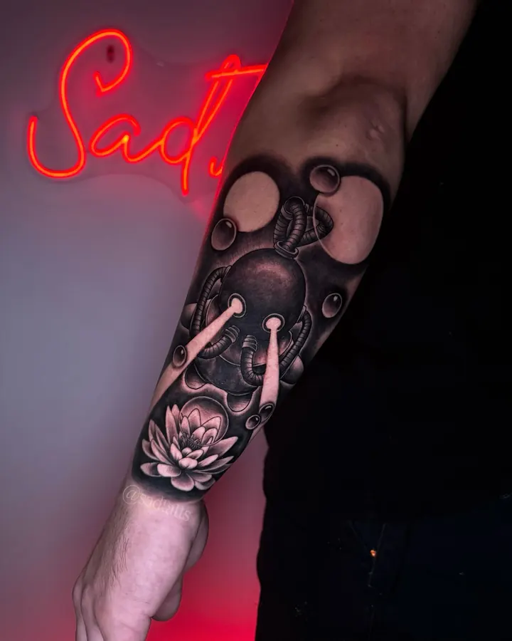 Black and grey tattoo by Dre: heart and lotus, forearm