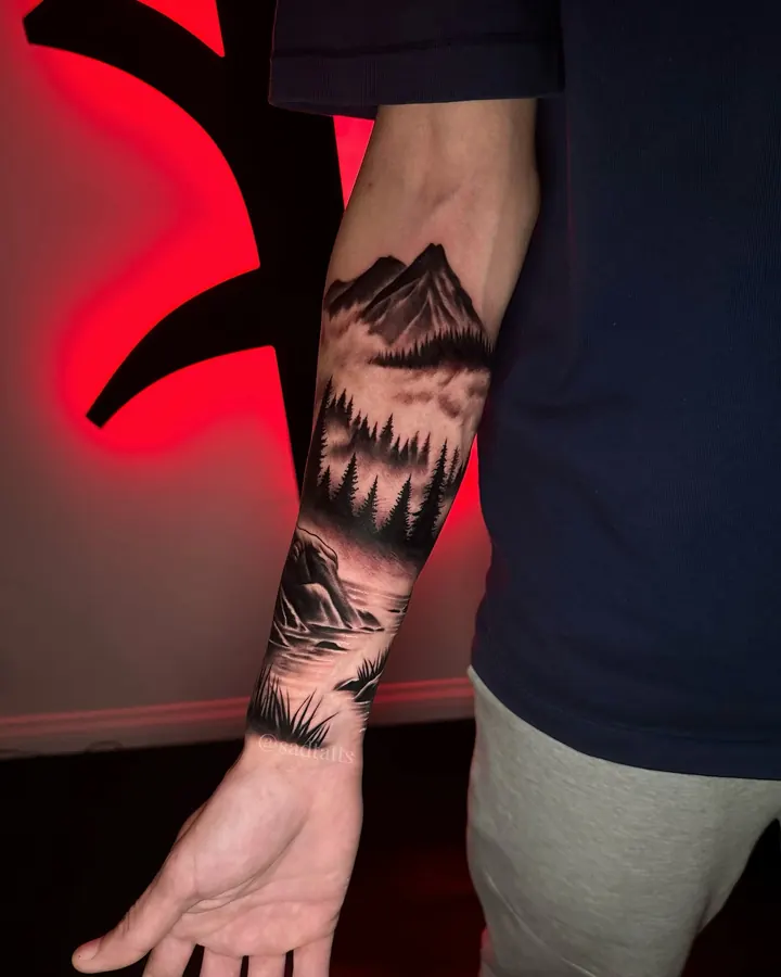 Black and grey tattoo by Dre: mountain landscape, forearm