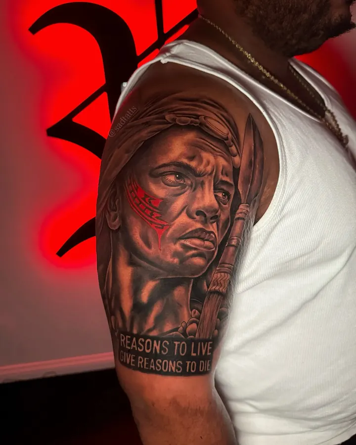 Black and grey tattoo by Dre: portrait with script, upper arm