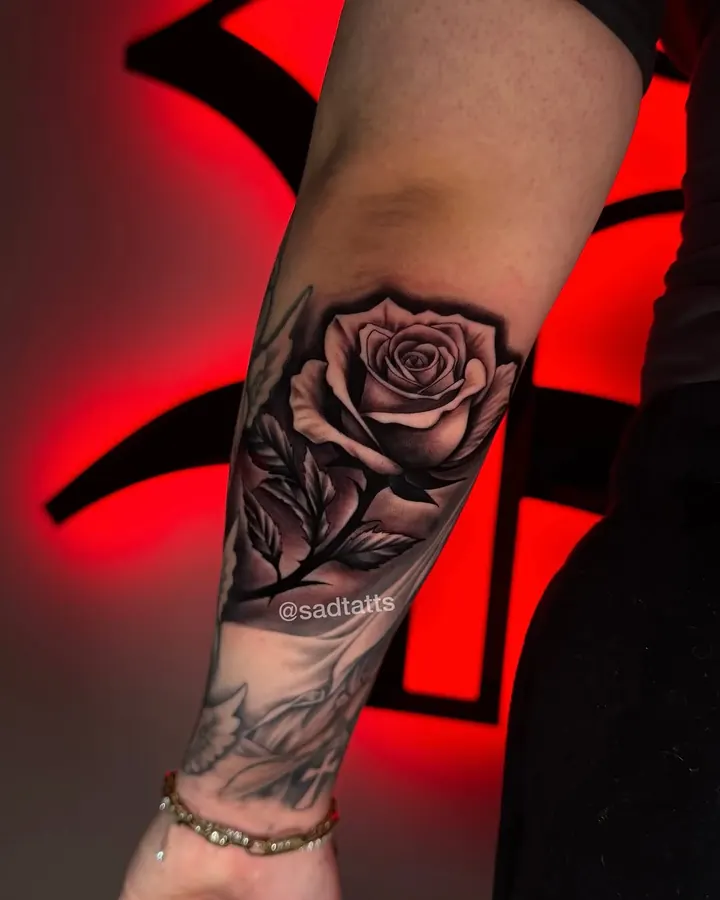 Black and grey tattoo by Dre: rose, forearm