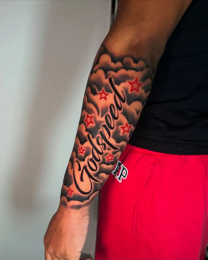 Black and grey tattoo by Dre: script lettering with clouds, forearm