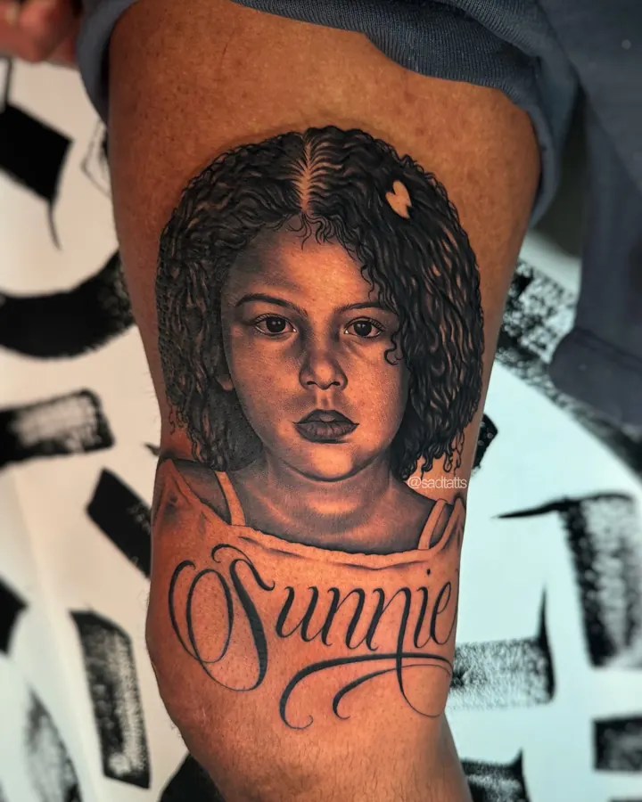 Black and grey tattoo by Dre: girl portrait, upper arm