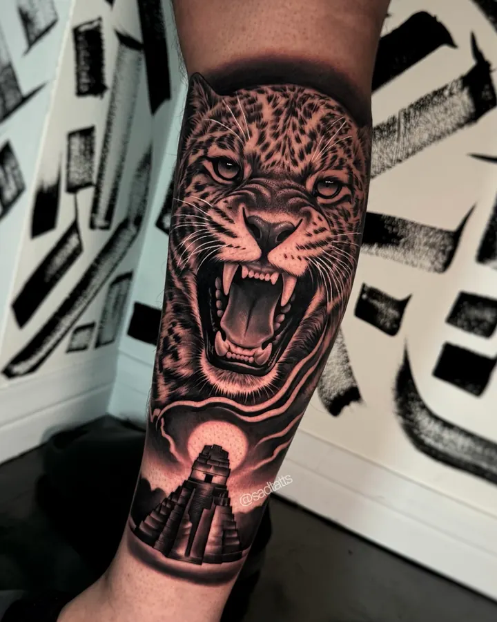 Black and grey tattoo by Dre: jaguar and temple, forearm