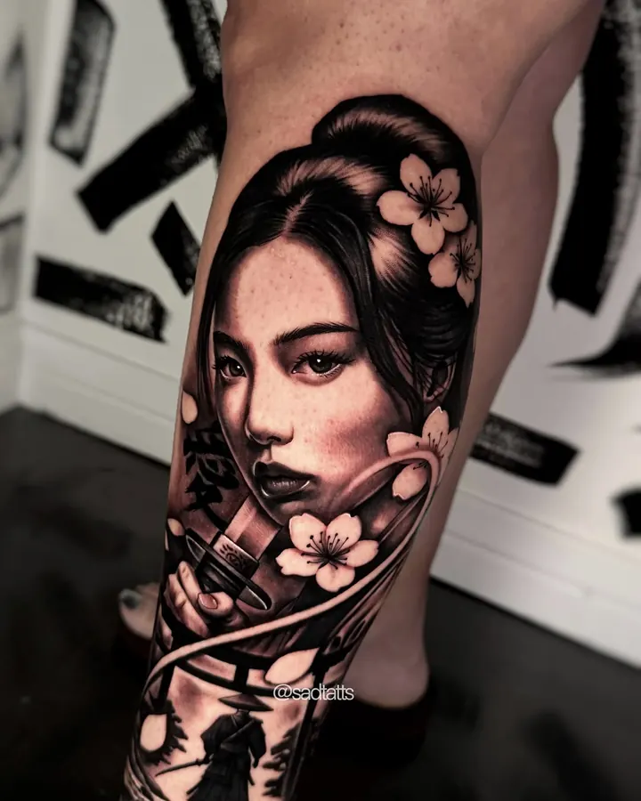 Black and grey tattoo by Dre: geisha with flowers, calf